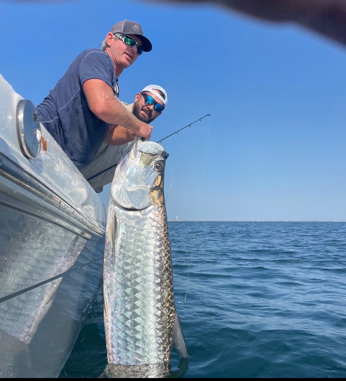 Two anglers with massive tarpon boat-side on Galveston charter